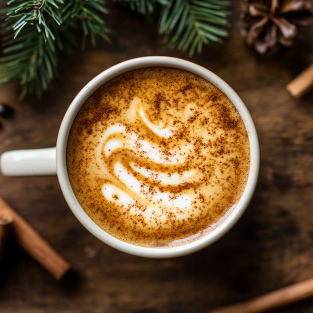 Gingerbread Syrup Swirled on a cup of Coffee  beside a decorated Christmas tree, with a sprinkle of cinnamon on a rustic wooden table.