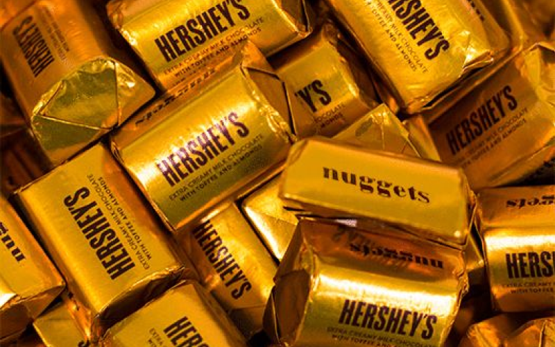 Nuggets chocolates wrapped in gold foil. The foil wrappers have the Hershey's logo printed on them, along with the word "nuggets" in brown text.